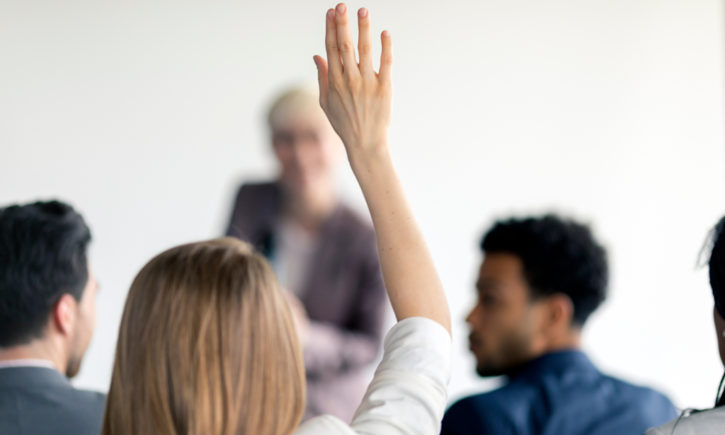 woman raising her hand to ask a question